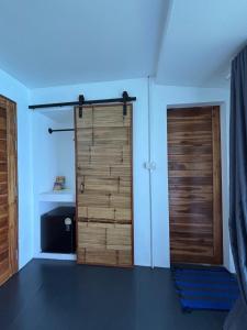 a room with two wooden doors in a room at Shark Bay room Turtle in Koh Tao