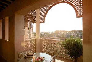 uma mesa com uma tigela de frutas na varanda em Jumeirah Al Qasr Dubai no Dubai
