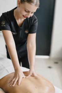 a woman is waxing a persons stomach on a table at Le Petit Manoir Boutique Hotel in Franschhoek +127 photos