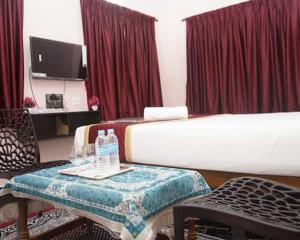 a hotel room with two beds and a table and chairs at RD Resort in Pondicherry