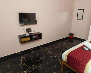 a room with a bed and a tv on a wall at RD Resort in Pondicherry +16 photos