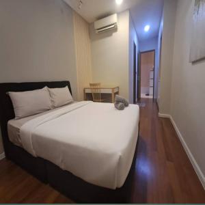 a bedroom with a large white bed and a table at Sky suites klcc by Elham in Kuala Lumpur
