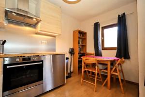a kitchen with a table and a stove and a dining room at Résidence Les Houches Villages - Houches Village B23 MAE-6424 in Les Houches