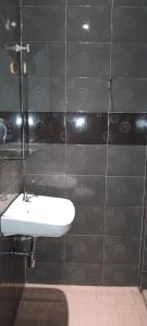 a bathroom with a sink and a black tiled wall at The 1975 Hotel Empire in Kuantan
