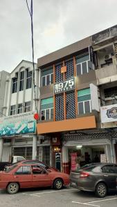 two cars parked in front of a building at The 1975 Hotel Empire in Kuantan