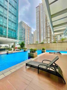 una piscina con un banco en un edificio en Uptown BGC Spacious Unit - 1 Queen bed and Bunkbed, en Manila