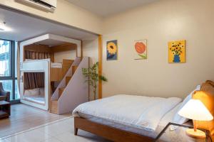 Un dormitorio con una litera y una escalera. en Uptown BGC Spacious Unit - 1 Queen bed and Bunkbed, en Manila 21 fotos más