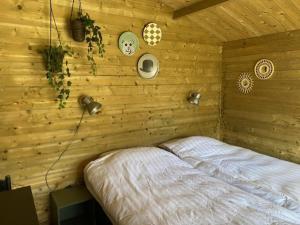 a bedroom with a bed in a wooden wall at Lodge op Recreatiepark de Uilenburg in Hommerts