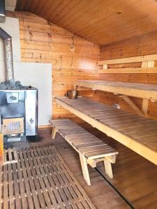 una sauna de madera con bancos de madera y fogones en Blue villa with private beach, en Kesälahti