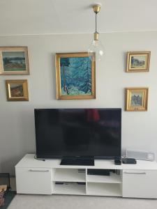 TV de pantalla plana en la parte superior de un centro de entretenimiento blanco en Blue villa with private beach, en Kesälahti