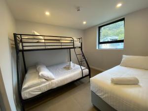 a bedroom with two bunk beds and a window at Blues Air 3A - Thredbo in Thredbo