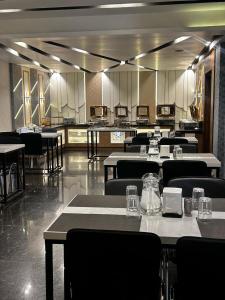 a restaurant with tables and chairs in a room at ROYAL ACE LUXUR in Bengaluru