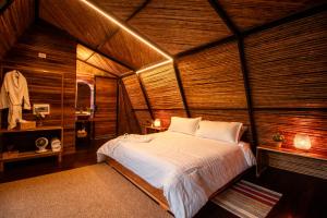 a bedroom with a bed in a wooden room at Ecolodge Palonegro in Lebrija