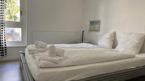 a white bed with towels on it in a bedroom at Seewohnung 2 in Spiez