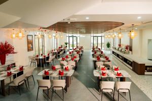 a restaurant with tables and chairs with red flowers on them at Belliss Hotel And Spa Dai Lai in Phúc Yên