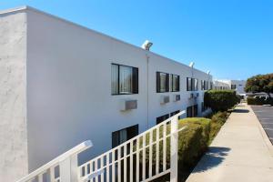 a white building with black windows and a sidewalk at Azul Inn San Simeon in San Simeon