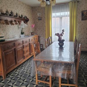 un tavolo da pranzo con un vaso di fiori sopra di La fermette d'etinehem a Étinehem