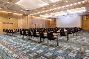 a conference room with tables and chairs and a whiteboard at Hilton Helsinki Airport in Vantaa