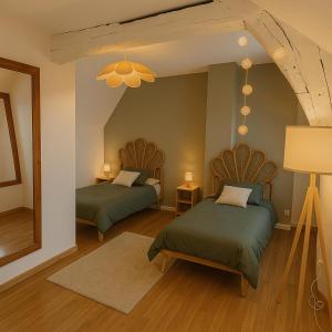 a bedroom with two beds and a large mirror at La maison du canal in Champforgeuil +7 photos