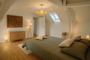a bedroom with a large bed and a skylight at La maison du canal in Champforgeuil