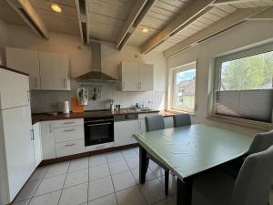 a kitchen with white cabinets and a table and a window at Dachgeschoss Wohnung mit Blick ins Grüne in Taunusstein