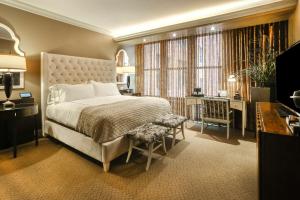 a bedroom with a large bed with a desk and a desk at Curtiss Hotel, an Ascend Collection Hotel in Buffalo +49 photos