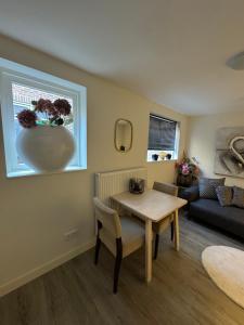 Hello Noordwijk - Zomerhuis Toekomststraat 8 في نوردفايك أن زي: غرفة معيشة مع طاولة ومزهرية على النافذة