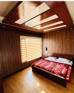 Un dormitorio con una cama en una habitación con ventana. en Woodfins Stay, en Mussoorie