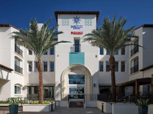 库卡蒙格牧场Sanctity Hotel Rancho Cucamonga, Tapestry Collection Hilton的一座前面有棕榈树的建筑