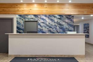 a reception counter in a room with a wall of marble at Baymont by Wyndham Moses Lake in Moses Lake +36 photos