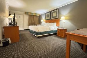 a hotel room with a bed and a desk at Rodeway Inn in College Station +15 photos
