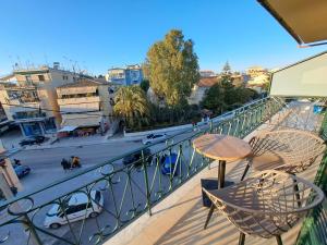 un balcone con tavolo, sedie e una strada di Finikas Apartment R203 a Corfu International Airport I Kapodistrias