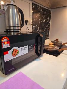 a microwave on a kitchen counter with a pot on it at Comfy Studio Neo Damansara Ikea Ikano 2Pax1CP in Petaling Jaya
