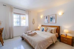 um quarto com uma cama grande e uma janela em Casa Maisie Apartment no Burgau