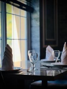 a table with glasses and napkins on top of it at Vorano Boutique Hotel Islamabad in Islamabad