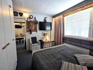 Un dormitorio con una cama y una silla y una ventana. en Revontuli 8, en Syöte