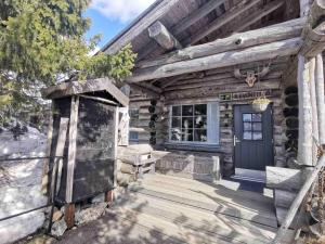 Cabaña de madera con puerta azul y porche en Revontuli 8, en Syöte