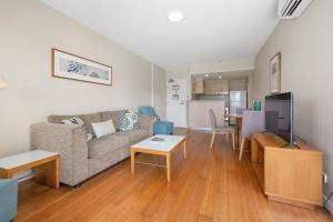 a living room with a couch and a table at Garden View Apartment in Mantra Salt Beach Resort by uHoliday - 2BR, 1BR and Hotel Room configurations available in Kingscliff