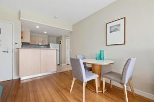 a kitchen and dining room with a table and chairs at Garden View Apartment in Mantra Salt Beach Resort by uHoliday - 2BR, 1BR and Hotel Room configurations available in Kingscliff