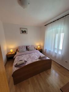 a bedroom with a large bed with two lamps on it at Malin Guesthouse in Skradin