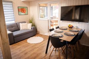 a living room with a table and a couch at White Nights holiday home with sauna and grill in Pärnu