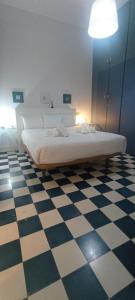 sypialnia z dużym łóżkiem na szachownicy w obiekcie Casas y Patios de Sevilla w Sewilli