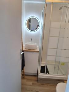 ein Badezimmer mit Waschbecken und Spiegel in der Unterkunft appartement T2bis idealement situé au bord du lac marin de Vieux Boucau in Vieux-Boucau-les-Bains + 7 Fotos