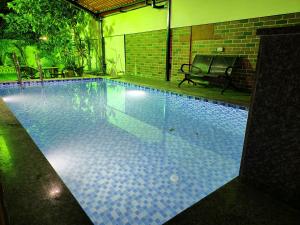 a swimming pool with a bench next to it at Taj Villa with free Wifi in Lonavala