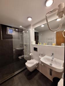 a bathroom with a toilet and a sink and a shower at Hotel Avion in Prague