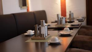 a row of tables with cups and saucers on them at Garni Hotel Hof zum Ahaus in Ahaus