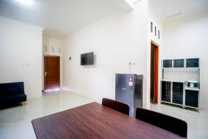 a dining room with a table and a refrigerator at Griya Godean Homestay Jogja in Godean