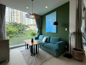 a living room with a blue couch and a table at Notre Maison 7 - COliving and COworking in Ho Chi Minh City
