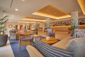 a lobby of a hotel with chairs and tables at Alua Calvia in Magaluf
