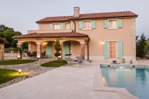 a house with a swimming pool in front of a house at Villa Beleca in Kras